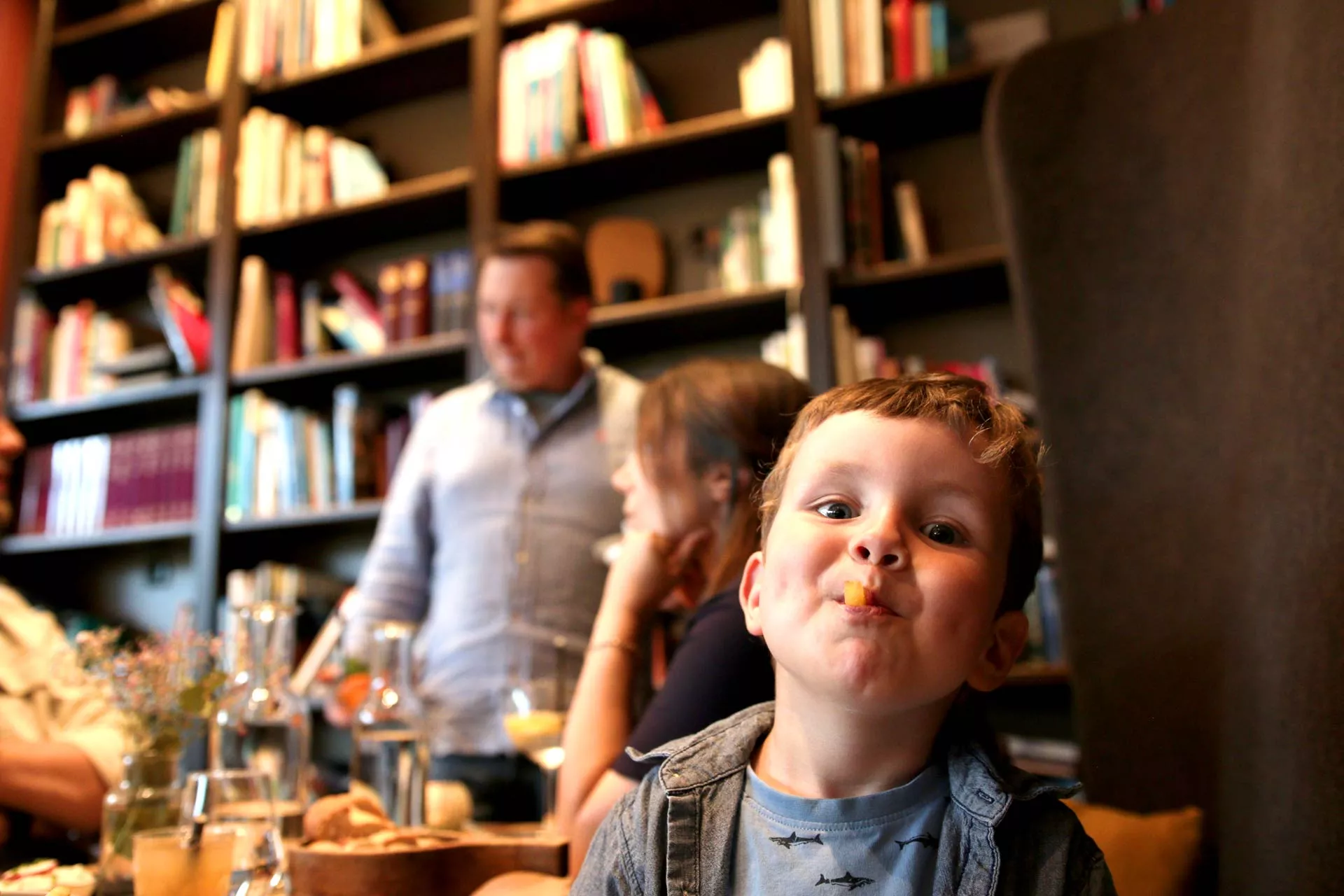 Junge / Kind beim Essen mit Pommes im Mund